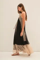 Vestido largo negro con breteles finos, escote en V y detalles de encaje color beige en el escote, laterales y ruedo.