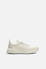 Zapatilla deportiva color crudo para uso diario y carreras ligeras. Parte superior de tejido de punto transpirable con puntera y talón recubiertos de material Shield Protect Max. Ajuste con cordones, tirador trasero y plantilla OrthoLite® extraíble. Entresuela con tecnología Spume Foam V3 y suela de goma.