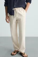 Pantalón verde oscuro de algodón con textura, corte recto, cintura elástica ajustable con cordón, bolsillos laterales y traseros de vivo.