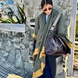 Bolso tipo tote de cuero color marrón, con doble asa de hombro y cierre superior.