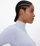 Polera verde de punto acanalado, con cuello alto y mangas largas.