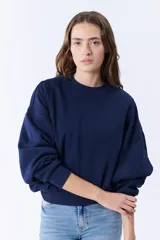 Buzo azul marino de corte holgado con mangas abullonadas y cuello redondo.