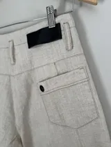 Pantalón marrón de lino y algodón, de tiro medio y piernas anchas, con bolsillos delanteros y traseros con detalles de remaches.