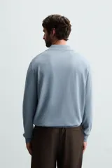 Polo celeste de punto con mezcla de algodón, seda y lino. Corte relaxed fit, cuello solapa con abertura frontal, manga larga y acabados en rib.