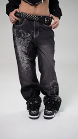 Zapatillas de skate negras con estampado de logos en blanco y gris, cordones gruesos negros, suela blanca y detalles en ecocuero.