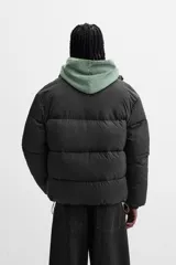 Campera puffer marrón con cuello alto, cierre frontal con cremallera, bolsillos laterales y puños elásticos.