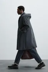 Parka larga color verde oscuro, con capucha desmontable, cuello solapa, bolsillos laterales y cierre frontal con cremallera oculta y botones a presión. Incluye chaleco interior acolchado desmontable.