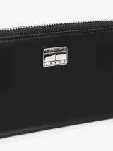 Billetera Tommy Jeans negra con cierre de cremallera y logo plateado en el frente. Incluye múltiples ranuras interiores para tarjetas, tres compartimentos principales, dos compartimentos interiores para billetes y un bolsillo interior con cremallera.