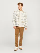 Sobrecamisa a cuadros color blanco, marrón y negro, de manga larga con cierre de botones y bolsillos en el pecho.