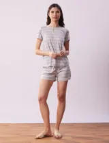 Conjunto de pijama gris a rayas horizontales blancas, compuesto por una remera de manga corta con cuello redondo y un short con cintura elastizada.
