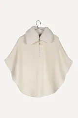 Poncho color crema con cuello de corderito desmontable y cierre dorado.
