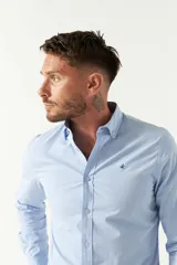 Camisa de hombre a rayas verticales azules y blancas, corte slim fit, con logo bordado en el pecho.