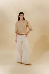 Pantalón de jean azul con corte sastrero de tiro medio bajo confeccionado en 100% algodón. Presenta cortes en los costados, dos bolsillos delanteros y dos traseros.