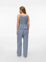 Pantalón largo de tiro alto con corte relajado, estampado a cuadros azules y blancos, cierre con cordón y bolsillos laterales.