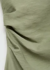 Vestido midi sin mangas de tejido fluido color verde, con bajo asimétrico y tirantes anchos.