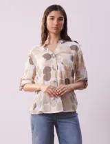 Blusa de algodón estampada marca Dash, con cuello a la base, escote en V y abertura con botones. Tiene un bolsillo en la parte delantera y mangas 3/4 regulables con presilla y botón.