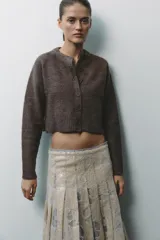 Chaqueta de punto color marrón con aberturas laterales y cierre frontal con botones.