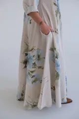 Vestido largo color beige con estampado de flores azules, corte amplio, escote en V y mangas 3/4.