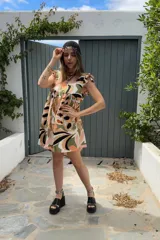 Vestido corto con estampado abstracto en tonos beige, naranja, verde y negro.