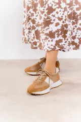 Zapatillas deportivas color beige con detalles metalizados dorados, perforaciones, cordones ajustables y suela de goma dentada.