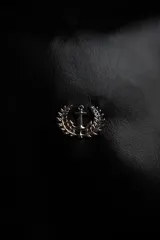 Bolso duffel negro de cuero sintético con logo de ancla bordado en rosa. Tiene doble asa de mano reforzada, correa de hombro regulable y desmontable, cierre superior con doble cremallera y tres bolsillos (dos exteriores y uno interior).