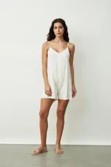 Mono corto color crudo, con breteles finos, escote en V y cierre frontal con botones.