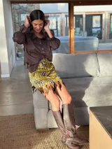 Minifalda negra de terciopelo con cintura elástica y ruedo con plumas.