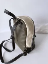 Mochila de cuero verde con detalles en blanco y negro.