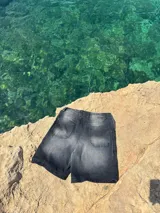 Short de jean negro con efecto lavado, corte a la rodilla y estampado con el logo de la marca en blanco en la pierna izquierda.