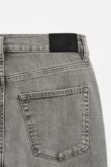Pantalón de jean azul oscuro, corte slim fit, tiro medio, cinco bolsillos, tejido elástico y efecto lavado.