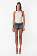Short de jean gris oscuro, tiro medio, con ruedo desflecado, pasacintos, cierre y botón metálico.