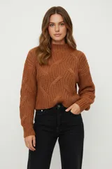 Sweater de punto grueso color marrón óxido, con cuello alto y diseño de trenzas en el frente y mangas.