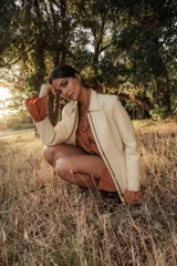 Campera de cuero color crema, con cierre frontal y cuello solapa.