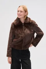 Chaqueta corta negra de piel sintética con cuello clásico, cierre frontal con cremallera y mangas largas.