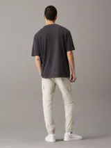 Pantalón cargo color beige de corte skinny, con cintura y puños elásticos, cierre de cremallera y botón de presión, bolsillos delanteros y traseros, bolsillos cargo con solapa, acabado ligeramente lavado e insignia con el monograma de Calvin Klein en la pierna.