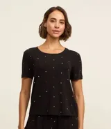 Blusa de pijama negra con lunares blancos y rojos, de manga corta y cuello redondo.