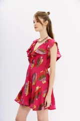 Vestido mini color fucsia con estampado de hojas multicolor, escote en V con volados, sin mangas y falda acampanada.