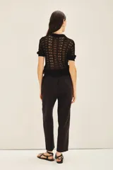 Pantalón recto negro de lino con bolsillos laterales y elástico interno en la cintura.