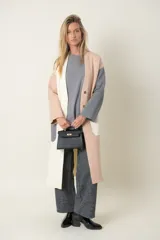 Saco largo en tonos pastel, con diseño combinado de color, dos bolsillos delanteros y cierre con broches.