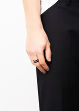 Anillo negro de acero quirúrgico hipoalergénico con línea plateada en el centro.