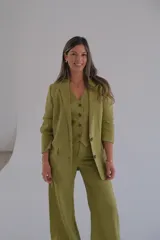 Conjunto de blazer, chaleco y pantalón color verde pistacho. El blazer es de corte clásico con solapas y cierre de dos botones. El chaleco es entallado con cierre de botones. El pantalón es de corte palazzo.