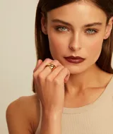 Anillo dorado con diseño retorcido de líneas suaves y orgánicas.