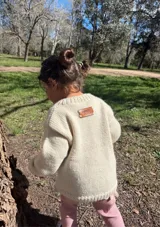 Sweater tejido de lana color crema con bordado de letras de colores formando la frase "Good Morning".