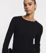 Suéter de punto color verde, con cuello barco, mangas largas y textura acanalada.