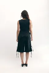 Bermuda gris satinada con corte recto, cintura elastizada, bolsillos frontales y tiras laterales para ajustar.