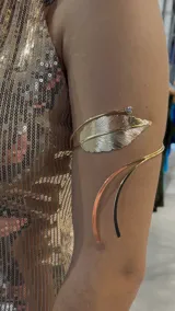 Brazalete dorado para el brazo con forma de hoja y detalle de strass.