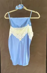 Pijama de satén elastizado color champagne, compuesto por musculosa con escote en V y detalle de puntilla elastizada, y short con elástico en la cintura y terminación con puntilla.