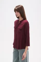 Camisa de manga larga con cuello mao y estampado paisley en tonos blanco, verde oliva y rosado. Presenta un calce holgado y bolsillos frontales.