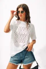 Camiseta blanca de algodón orgánico, corte oversize y manga corta, con un estampado frontal de círculos concéntricos rojos punteados.