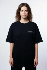Remera negra oversize de manga corta, con estampa en la espalda con la frase "PRAY X MERCY SS24" en rojo y blanco.